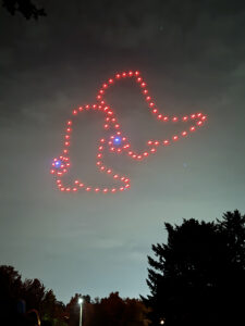 Lighted drones in the sky, in the shape of two boots